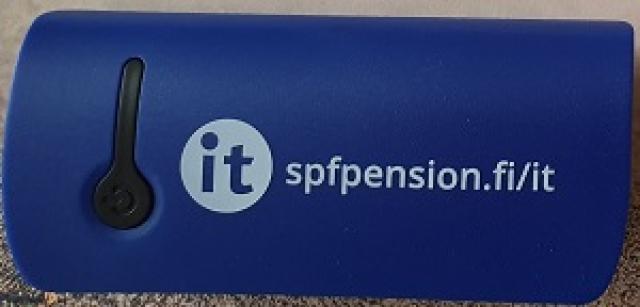 Fotografi av ett blått reservbatteri med vår it-logo och adressen spfpension.fi/it